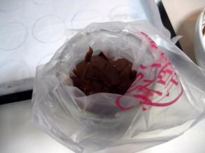 将裱花袋套在广口的玻璃瓶上，把拌好的面糊倒入裱花袋中；