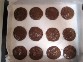 烤箱预热190度；把巧克力派面糊挤入烤盘中，尽量让面糊直径和厚度一致；放入烤箱中层烤13分钟左右（时间和温度请依自家烤箱情况灵活掌握，只要烤好的派不沾油纸，轻松取下即可。）