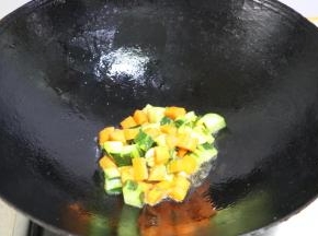 放入胡萝卜和黄瓜丁，翻炒至八分熟盛出