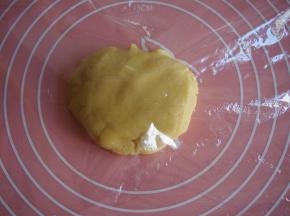 在面板上铺上一层保鲜膜，放上面团，上面再覆盖一层保鲜膜