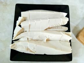 把内酯豆腐外包装用刀小心划开，内酯豆腐完整装入盘中，然后用刀划成小块备用