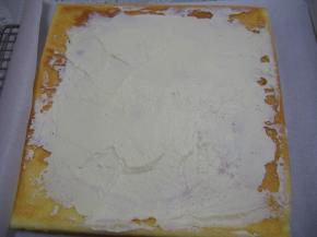 烤好的蛋糕片铺在油纸上，晾至温热后将淡奶油打发，抹在蛋糕上