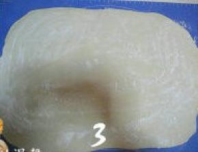 发好的面团揉搓至完全排气，再擀成3mm厚的方形面片，在面片表面撒干粉；