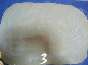 发好的面团揉搓至完全排气，再擀成3mm厚的方形面片，在面片表面撒干粉；