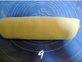 然后将压叠好的面片卷在擀面杖上，边擀边用手将面团向两边压；