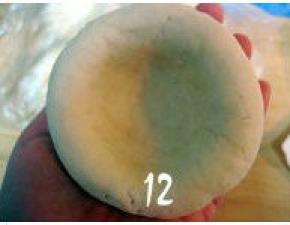 取一面团按扁，把面团按成中间薄四周厚的圆形饼坯；