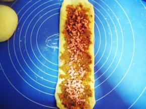 在沙拉酱上先撒上适量的肉松，再放火腿粒（不用火腿粒，放火腿更好吃，火腿长短可根据面团情况来定）；