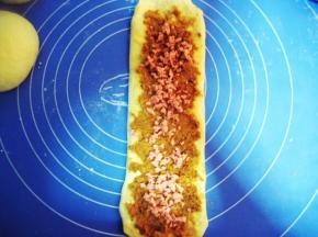 在沙拉酱上先撒上适量的肉松，再放火腿粒（不用火腿粒，放火腿更好吃，火腿长短可根据面团情况来定）；