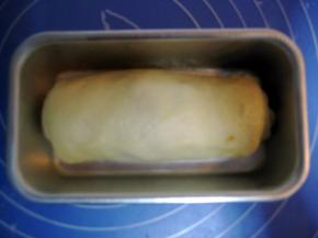 非不沾模具涂上软化黄油，把卷好的面团放在模具里（不用模具也行，直接把卷好的面团放在垫上锡纸的烤盘里也行）；