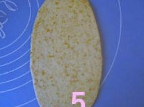 取一松驰好的面团，压扁，擀成椭圆形；
