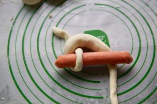 再把下面的面团穿过去，看着有点像锁住香肠的意思。文字难叙述，看图就容易理解了