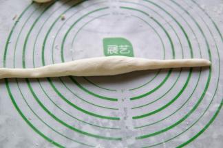取一块面团，搓长，如图所示，中间胖，两头瘦