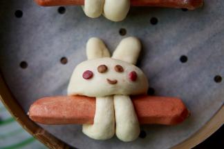 取出之前发酵好的可可粉面团和红曲粉面团，做成兔子的眼睛嘴巴和腮红