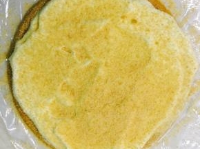 将淡奶油打发，加入充分软化的黄油和炼乳，底下放置保鲜膜，放一个饼皮，涂一层奶油，筛上一层饼边碎