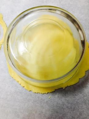 取一个直径大概20厘米的圆形容器，扣在面片上，压出一个圆形，多余的边儿，不要扔，有用处哦