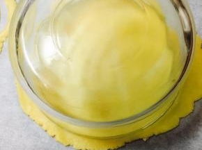 取一个直径大概20厘米的圆形容器，扣在面片上，压出一个圆形，多余的边儿，不要扔，有用处哦