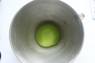 然后先用慢速1档把所有材料搅成团，再转4档高速搅拌面团到成团，揉好后的面团，拿出来揉成圆，放在桶里，用保鲜膜盖住，进行静置一小时（因为现在是夏天室温过高，所以要放在冰箱里冷藏静置）