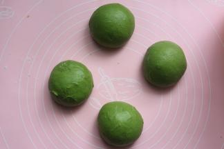 做好的面团拿到揉面垫上，分成4个等份，分别揉圆，盖上保鲜膜，进行室温醒发15分钟