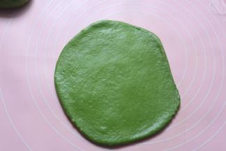 醒发好的面团，拿一个面团出来，用擀面杖擀成舌形状，