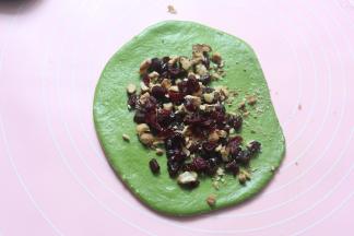 然后翻面放上馅料，再由上往下卷起来，