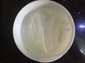 将扇贝一分为二，去掉里面黑色的东西和边上的沙线，清洗干净，将肉取下来，留下带花纹的贝壳，将粉丝放入水里泡软