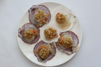 将炒好的蒜蓉平铺在贝肉上，淋上一点点油