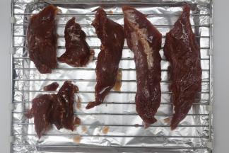 腌好的肉拿出来，烤盘先垫上锡纸，再放上烤网，把肉放在烤网，再在肉的表面刷上一层蜂蜜