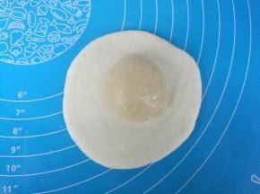 油皮擀成片，包住油酥，捏紧收口。