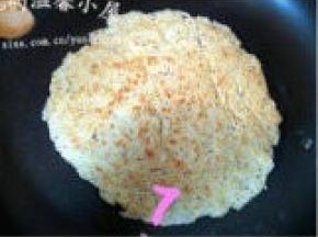 等豆渣饼一面烙成金黄色后，翻面，将另一面豆渣表烙至金黄，盛出，切块装盘。