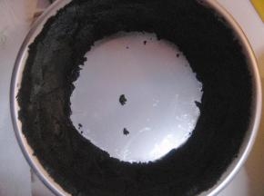 取步骤4中的部分饼干，放入模具内侧面，用勺子将饼干与模具侧面压实；