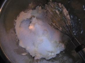 把细砂糖放进软化的奶油奶酪中，用打蛋器搅拌均匀；