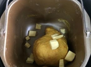 揉至约10分钟成团时，加入黄油。