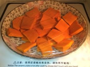 把南瓜去皮切片状放入盘中，盖好保鲜膜放入微波炉加热两分半钟至熟。