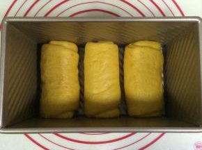 把长舌状面片卷起，放入450克吐司模中。
