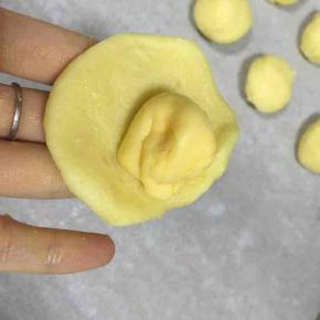 取一个小面团压扁，包入芝士片