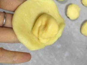 取一个小面团压扁，包入芝士片