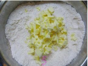 将软化的黄油倒入面粉中；