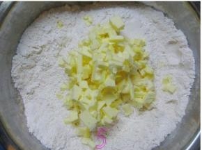 将软化的黄油倒入面粉中；