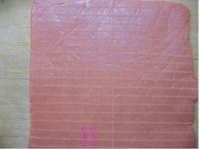 15分钟后当面团稍微变硬时取出，用剪刀剪开保鲜袋，拿尺子比着在饼干皮上画出宽8mm长条形；