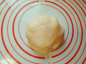 南瓜泥中加入糯米粉。揉成面团，盖上保鲜膜，松弛10分钟。