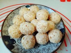 取一小块面团搓成小球，沾满芝麻即可，(如果不好粘芝麻的话，可以先将南瓜球沾些水，再沾满芝麻。)