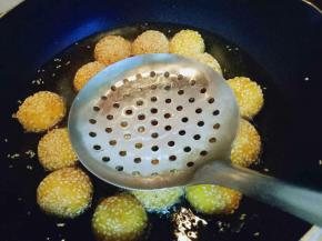 炸至麻球全部飘起来，用漏勺轻轻的按麻球，反复多次按压，麻球明显的变大，继续小火炸至两面金黄即可捞出。
