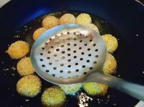 炸至麻球全部飘起来，用漏勺轻轻的按麻球，反复多次按压，麻球明显的变大，继续小火炸至两面金黄即可捞出。