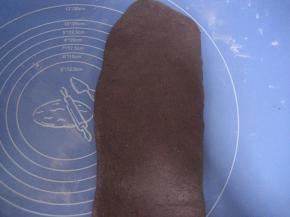 用擀面杖轻压面团，从中心向面团上下两边擀压，排出面团中的空气；将面团擀成长方形面片；