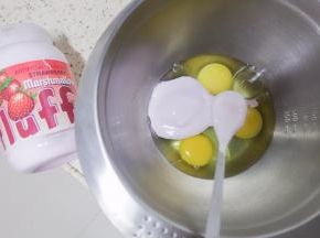  准备无水无油的容器放入3个鸡蛋一次性加入fluff液体草莓味棉花糖/白砂糖