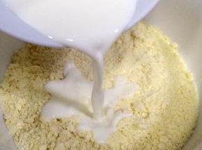 加入牛奶，用刮刀翻拌均匀至无干粉状态。