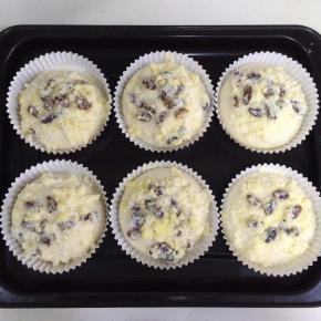 把葡萄干椰蓉泡浆用勺子淋到面团上。