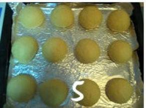 将松驰好的面团再次排气、滚圆，放入烤盘中，盖上保鲜膜进行二次发酵；