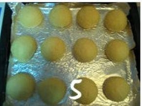 将松驰好的面团再次排气、滚圆，放入烤盘中，盖上保鲜膜进行二次发酵；