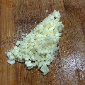 茄子烤制的过程准备配料：蒜瓣剁碎。